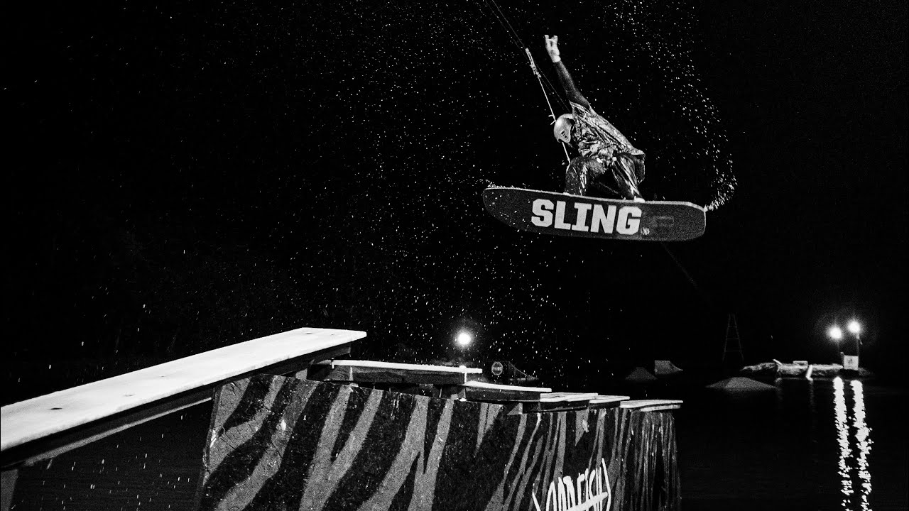 Wakeboarder catching big air off a rail during a night session at Zuno Cable Park